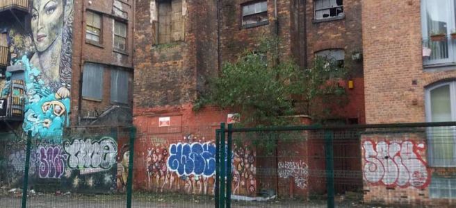 A derelict building with smashed windows and graffiti in Manchester