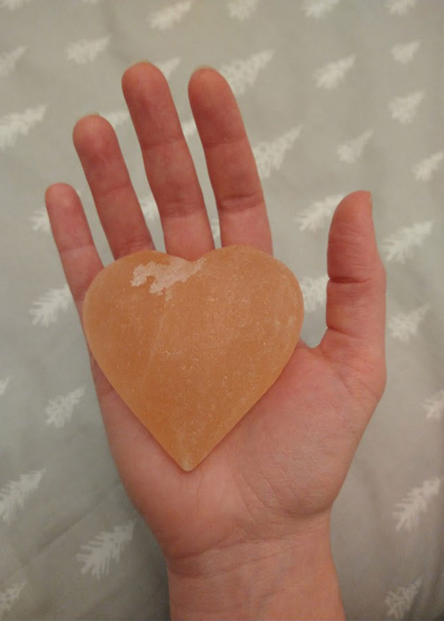 A heart-shaped bar of Himalayan salt in the palm of my hand for size reference.