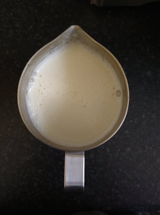 Frothy soya milk in the frothing jug.