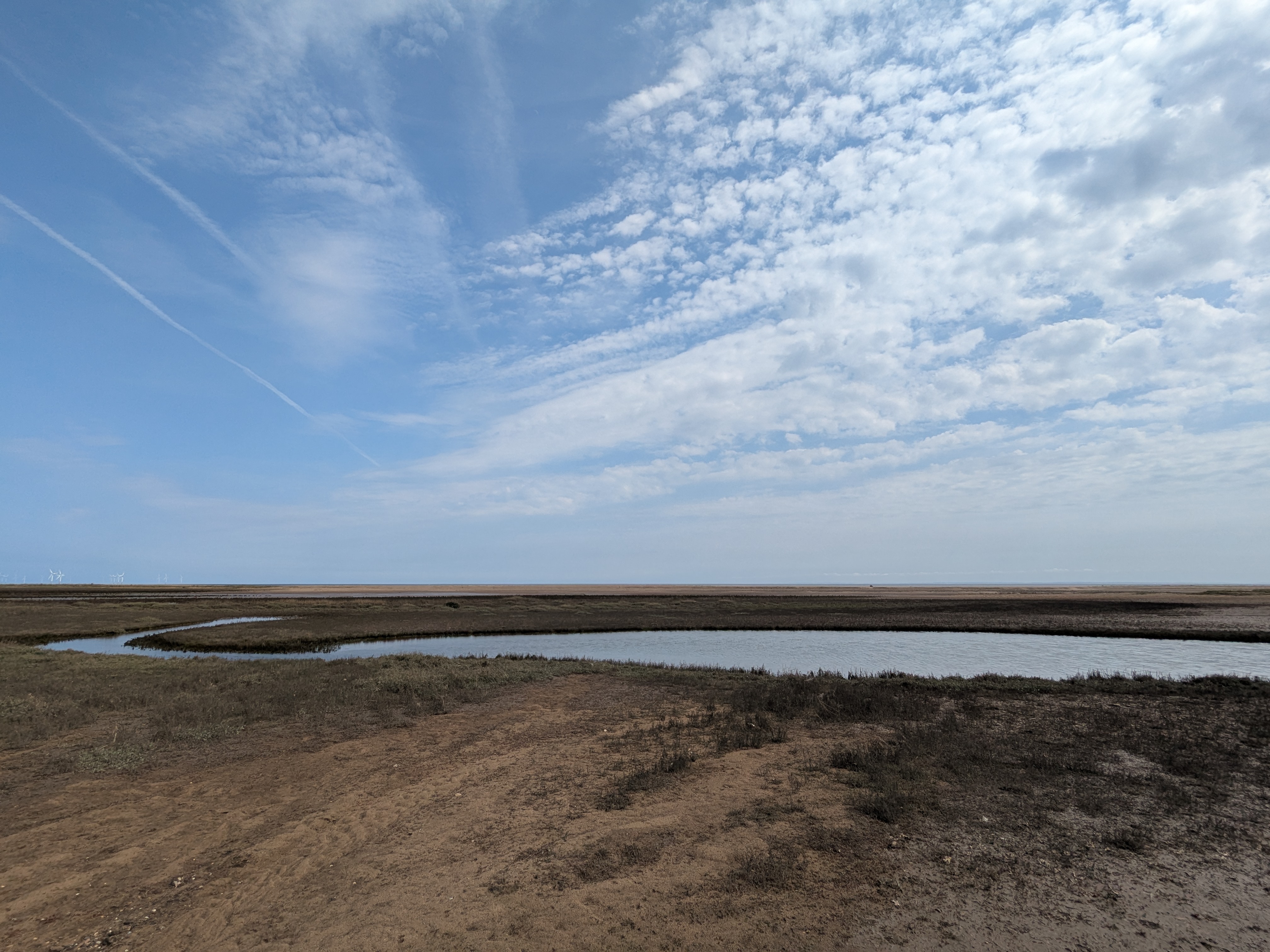 Coastline at Gibraltar Point, with sand dunes and a large stream joining the sea.
