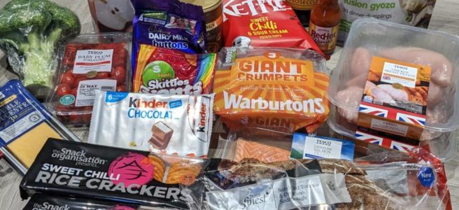 A food shop with lots of plastic packaging, including Pepsi Max, chilli crackers, chicken breast, broccoli, cucumber, crisps, tomatoes, and more.